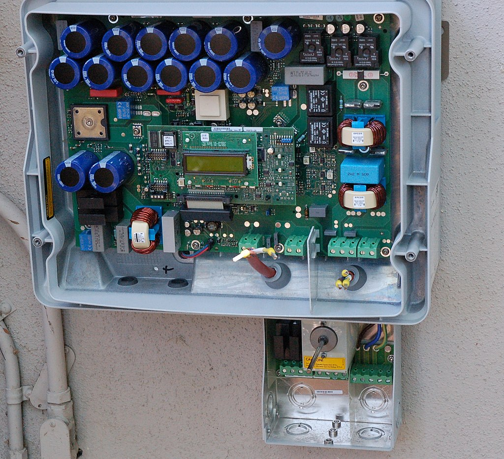 Internal view of a solar inverter. Note the many large capacitors (blue cylinders), used to store energy briefly and improve the output waveform.